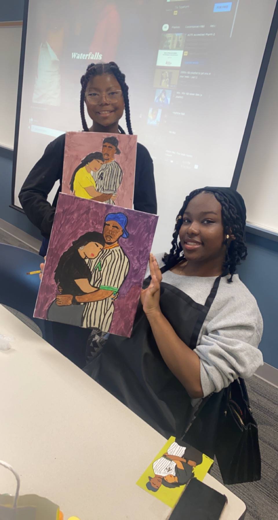 2 NIARA students holding their paintings